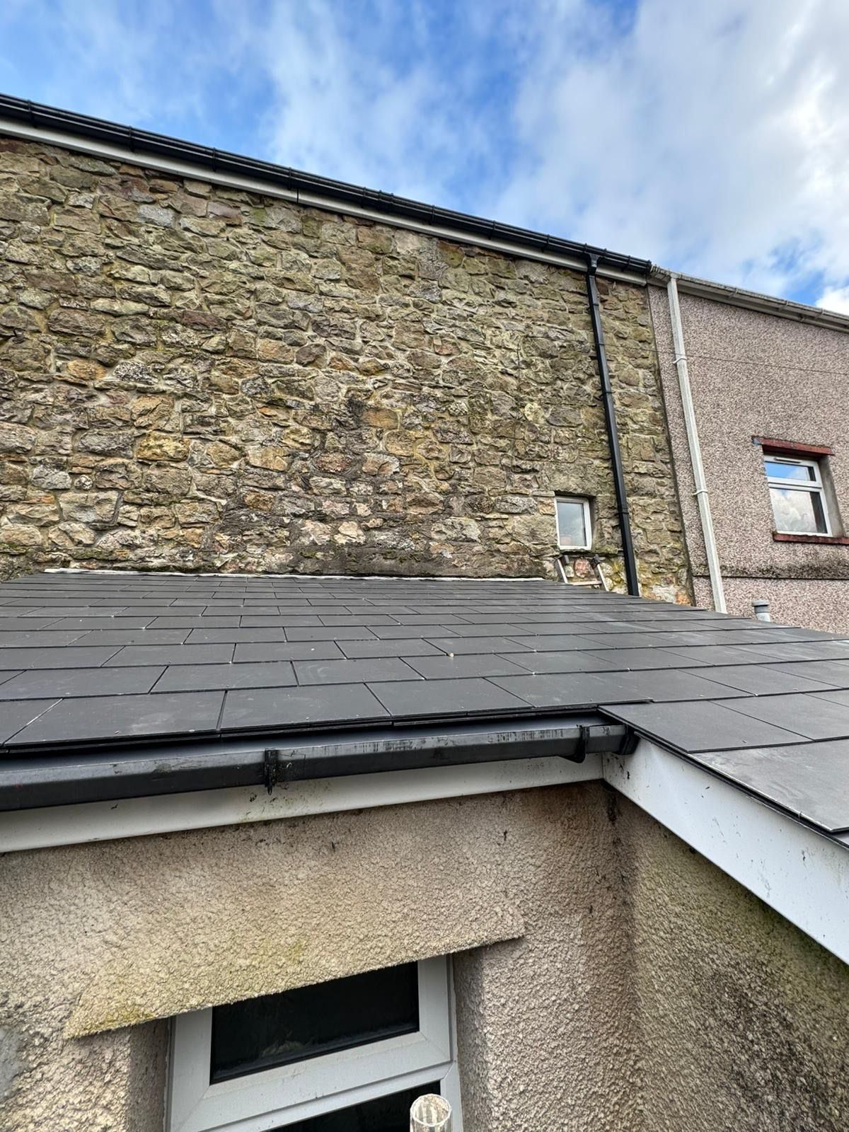 Guttering and downpipe installation alongside a new porch roof